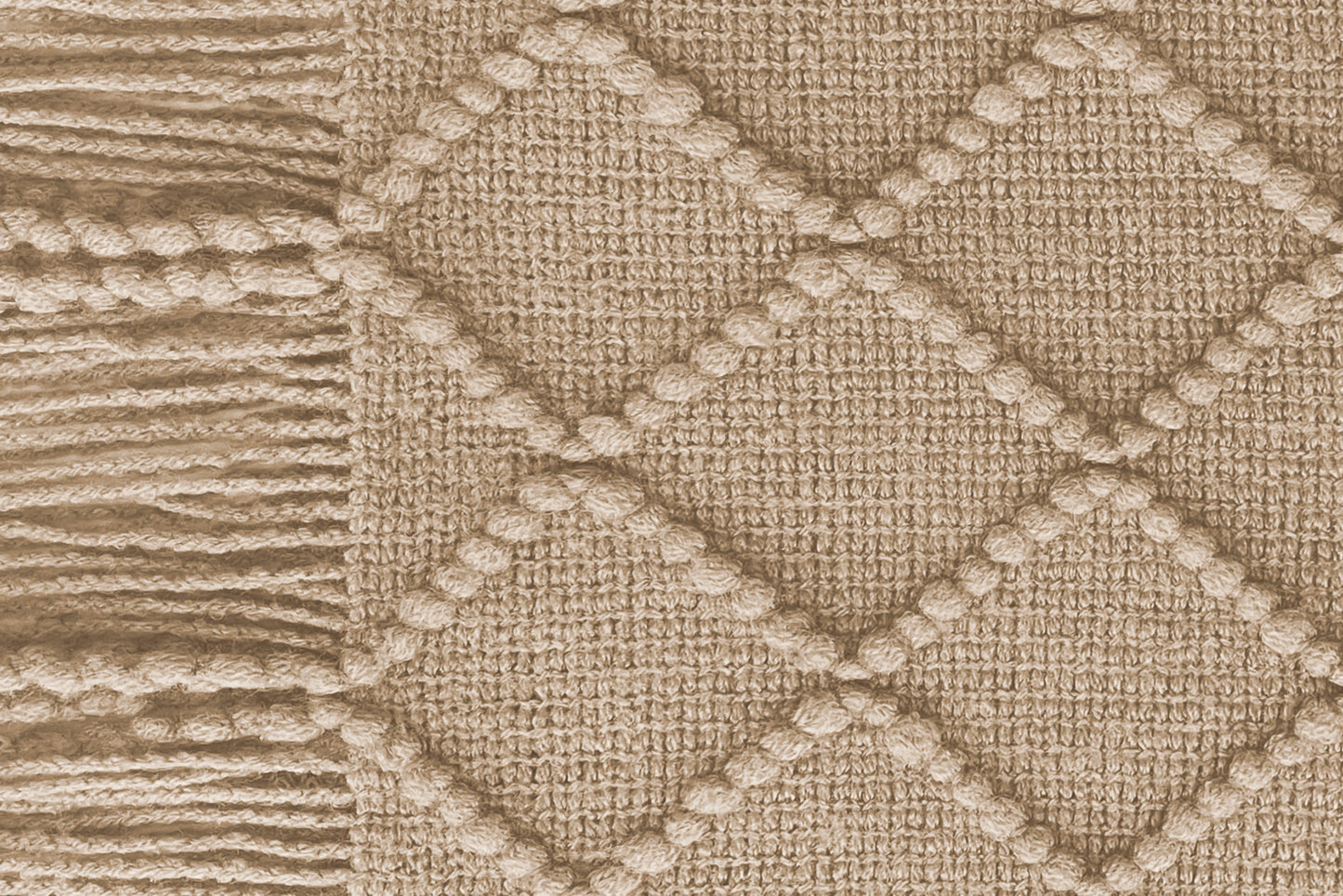 Close-up of a woolen heated sofa blanket with tassels in the colour Taupe Dawn with a geometric pattern