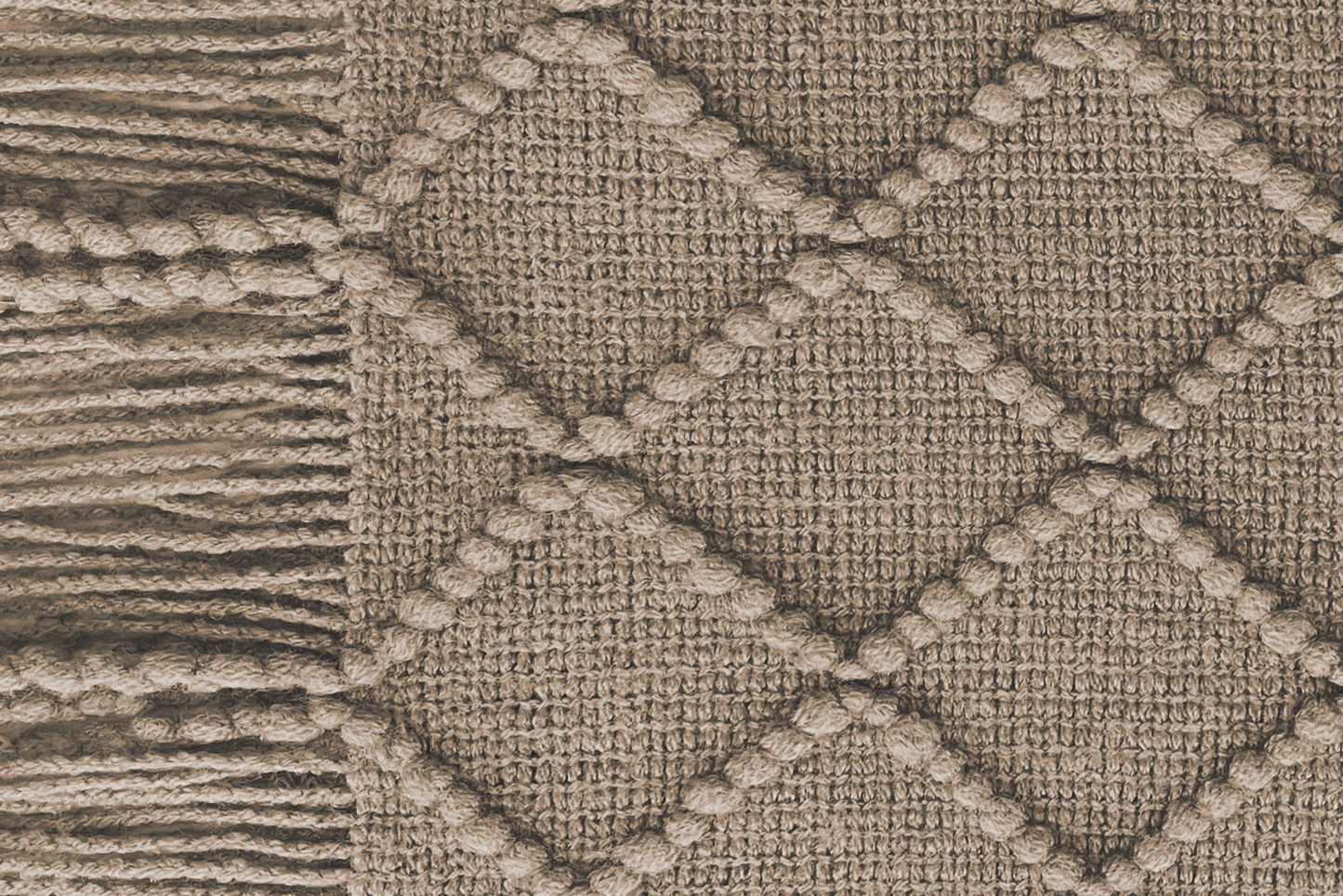 Close-up of a woolen heated sofa blanket with tassels in the colour Umber Wood with a geometric pattern