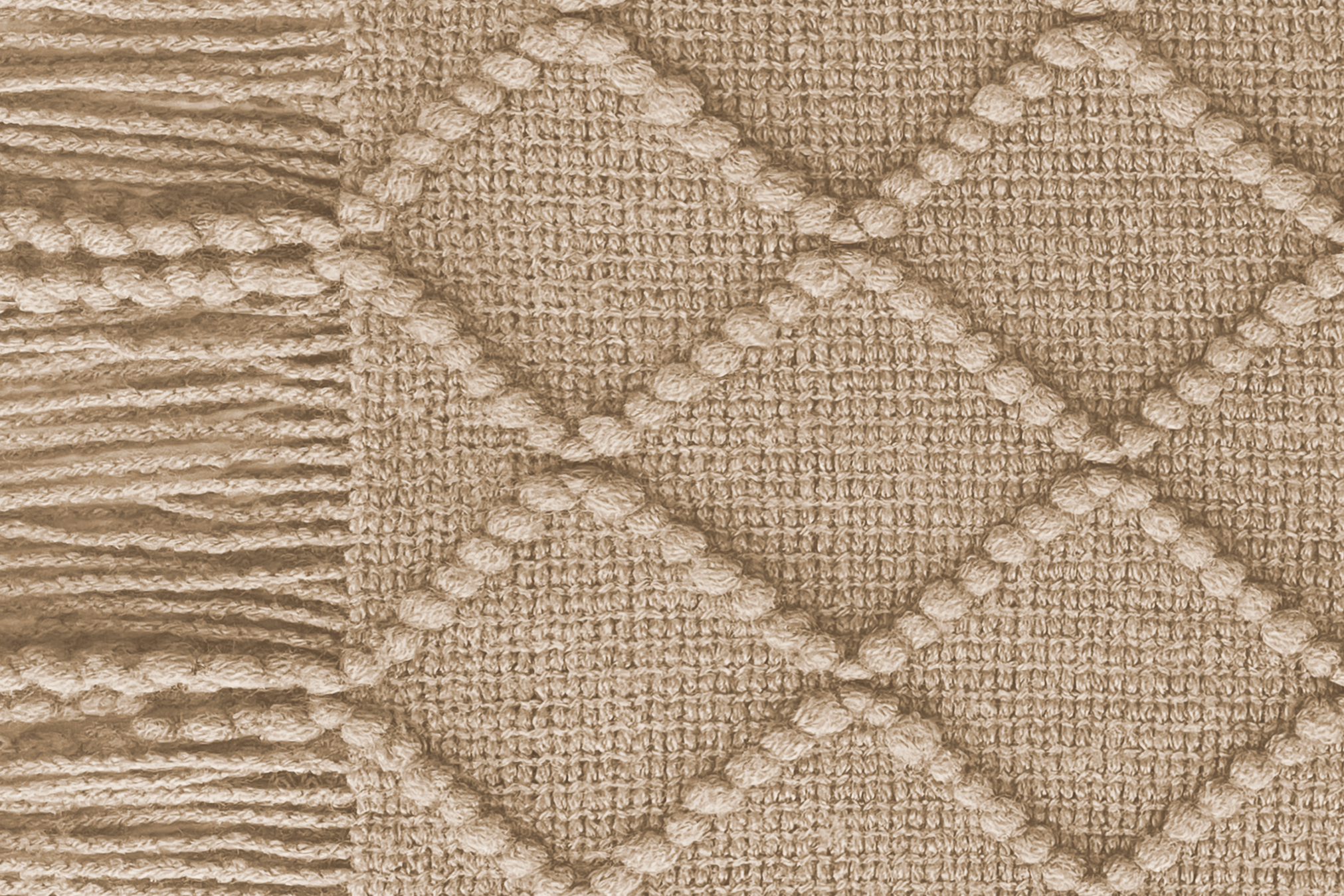 Close-up of a woolen heated sofa blanket with tassels in the colour Taupe Dawn with a geometric pattern