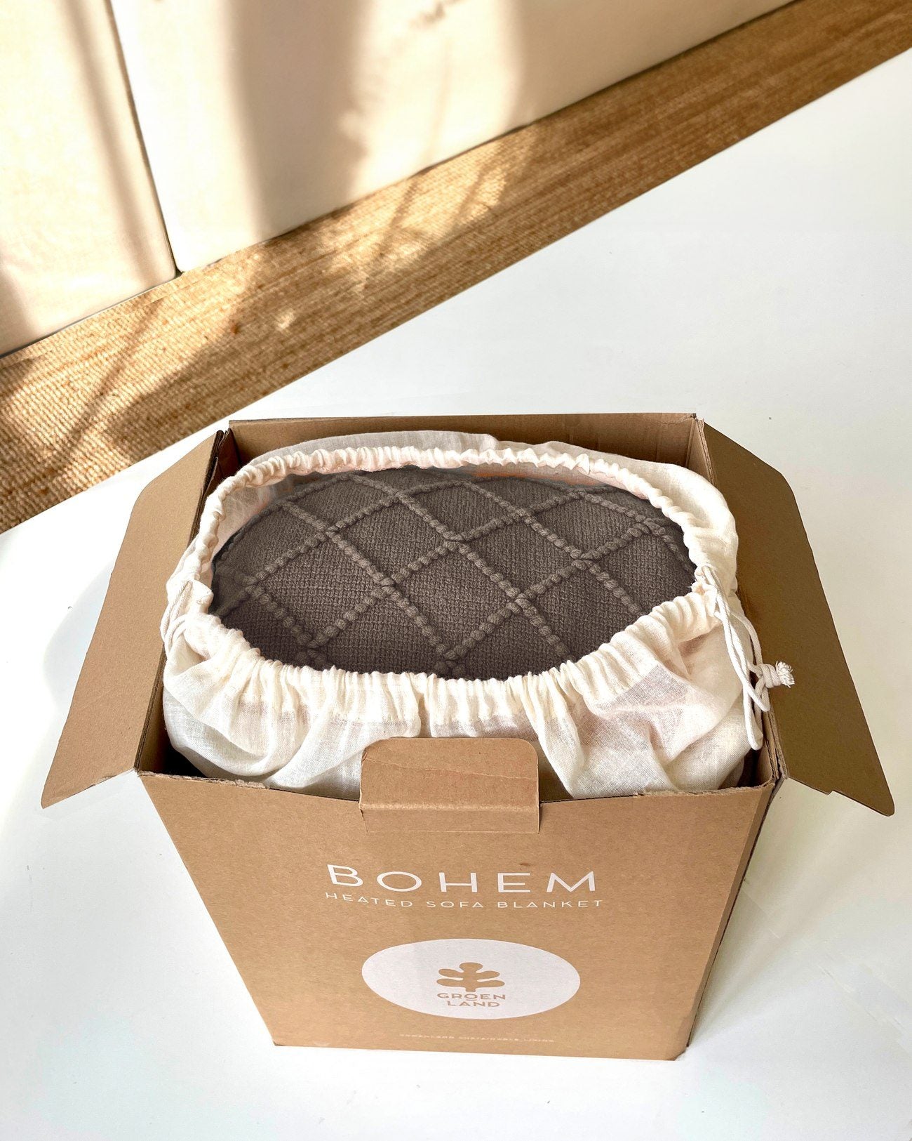 An open kraft gift box with a BOHEM folded inside its cotton bag